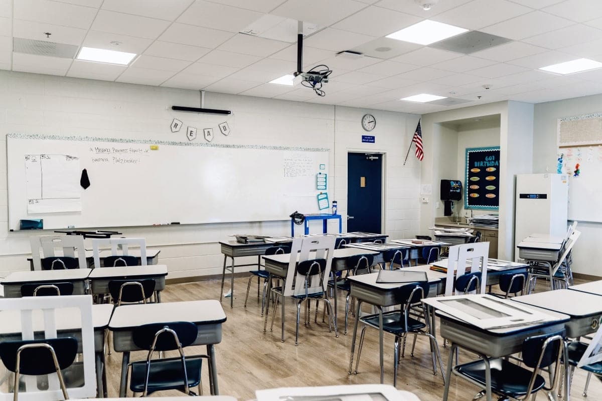 K-12 School Districts - a tidy, empty classroom with student desks and a U.S. flag